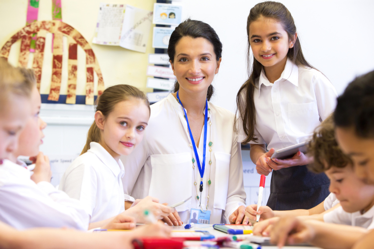 A teacher aide supporting learning in an Australian classroom.