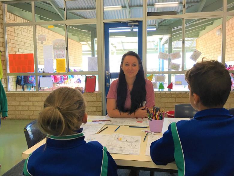 female SSO and students learning from workbook