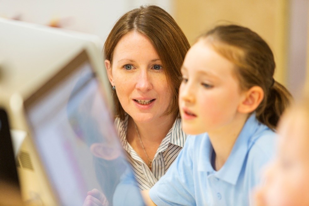 Teacher aide working in a computer lab.