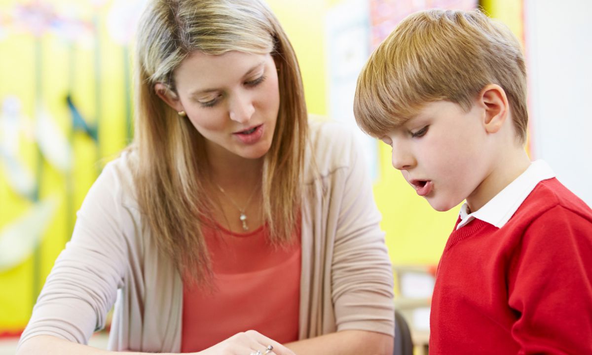 Teacher aide supporting a reading program.