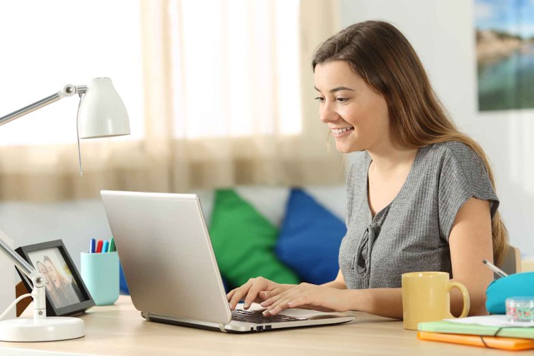 Young white female studying course via laptop in living room