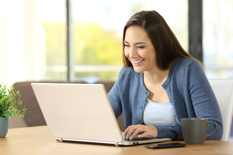 Teacher aide sitting at desk learning with smile