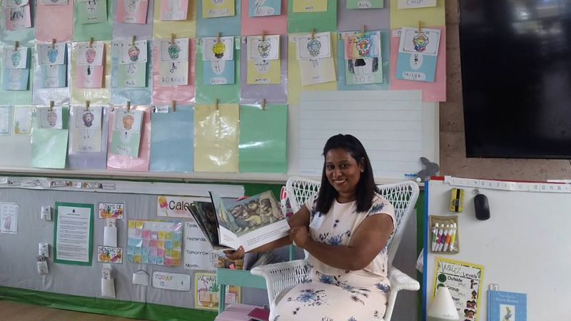 Teacher assistant giving a book presentation to students.