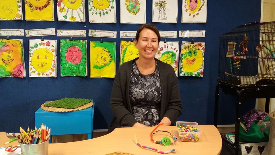 Teacher assistant sitting at a desk at a school.