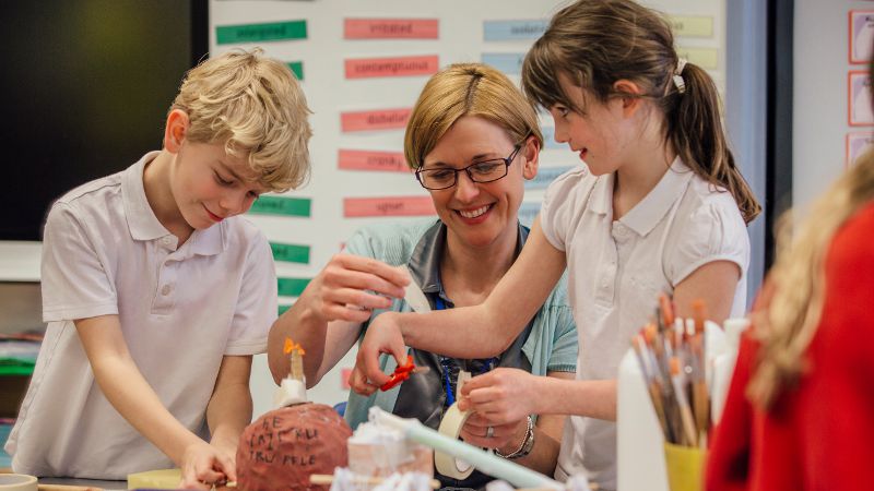 Teacher assistant working with students in a school.