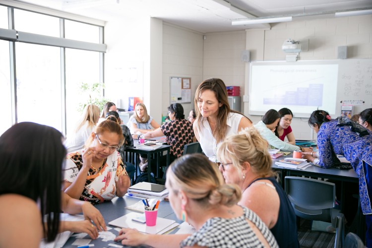 ITAC students and teacher in class studying a teacher aide course